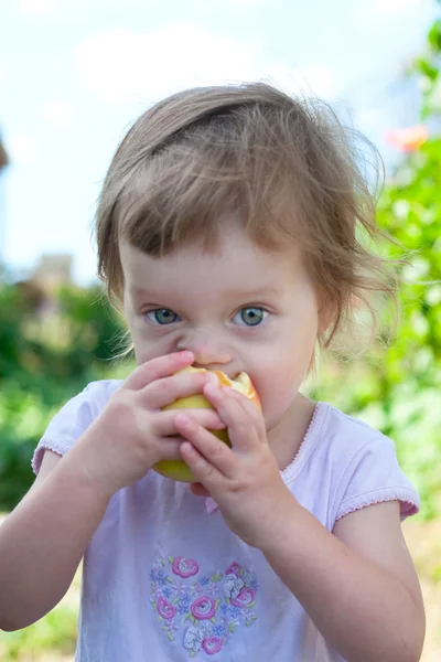small girl bite off juicy apple
