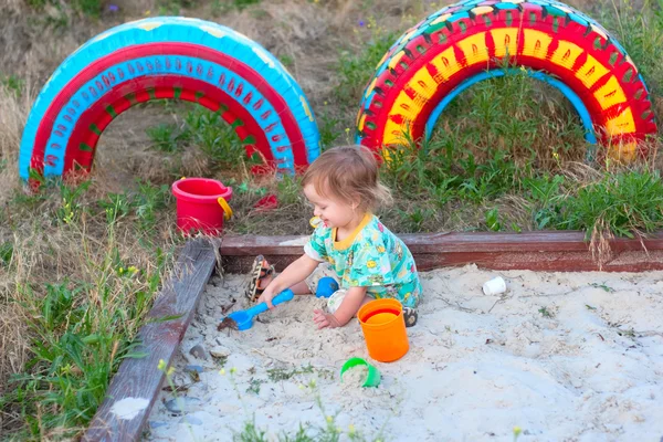 Criança pequena feliz jogar na caixa de areia — Fotografia de Stock