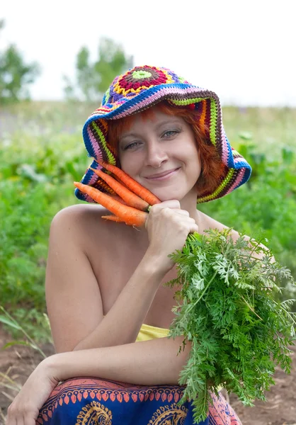 red-haired woman with bunch of carrots