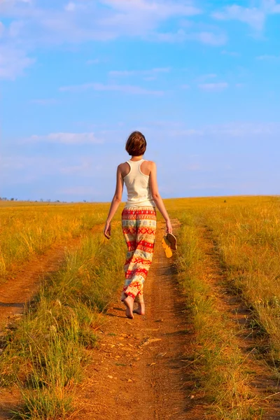 Mulher esbelta para andar na estrada da terra — Fotografia de Stock