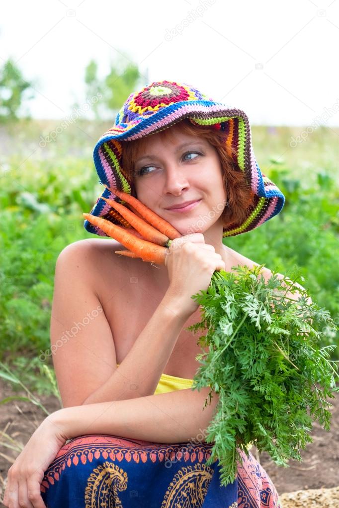 dreamy woman with bunch of fresh carrots