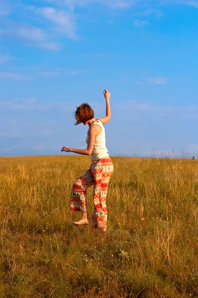 Belle femme danse pieds nus sur la prairie — Photo