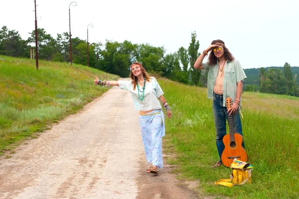 Casal carona hippie na estrada — Fotografia de Stock