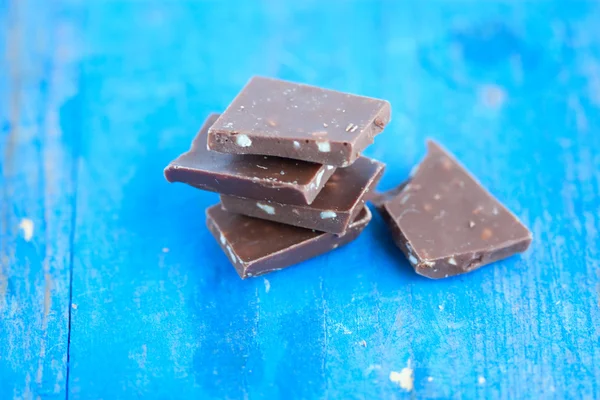 Chocolate de leite em barras na tábua azul — Fotografia de Stock