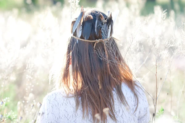 Mladá žena v koruně s peřím — Stock fotografie