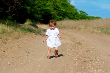 Beyaz elbiseli küçük bir gülümseme çocuk