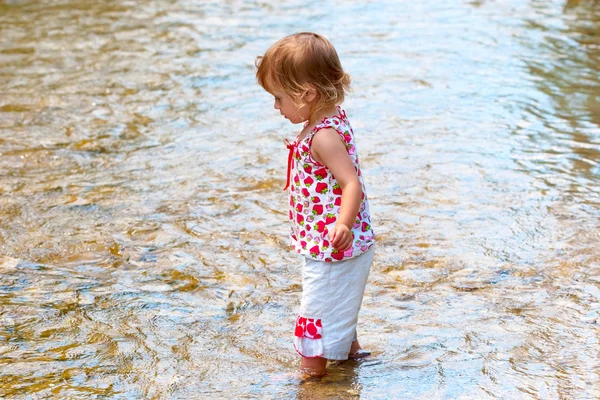 Criança pequena brincar na água rasa — Fotografia de Stock
