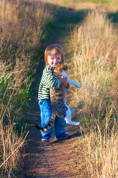 Sourire enfant tenir chat dans les mains — Photo