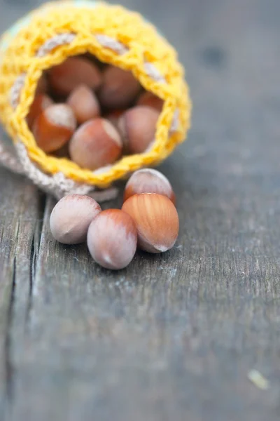 Crocheted yellow bag with hazelnut — Stock Photo, Image