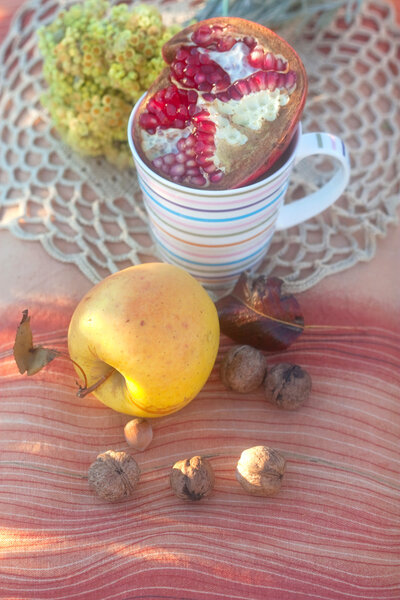 Apple and striped can with pomegranate