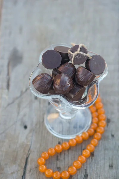 Candy in a glass vase and beads — Stock Photo, Image