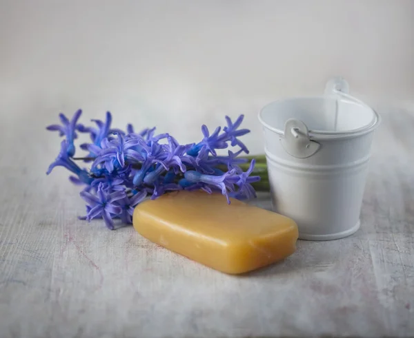 Jabón, flores moradas y cubo pequeño — Foto de Stock