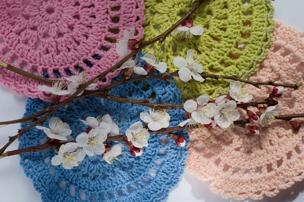 Colorful crocheted napkins and flowering branches — Stock Photo, Image