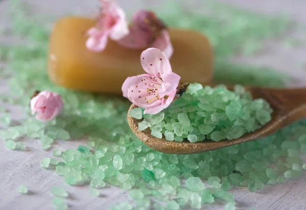 Baño de sal en una cuchara de madera, jabón y flores — Foto de Stock