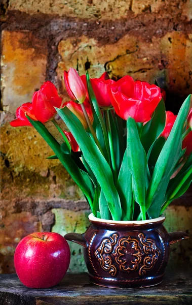 Bouquet of tulips and ripe apple — Stock Photo, Image