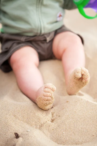 Bebé pies cubiertos de arena de playa — Foto de Stock