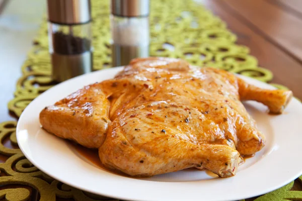 Pollo entero sin cocer en un plato blanco —  Fotos de Stock