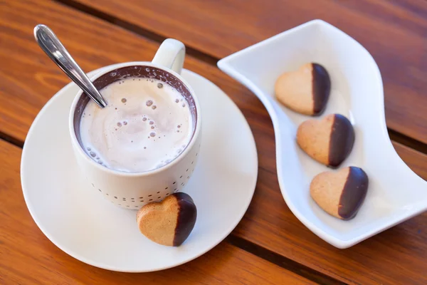 Chocolate dipped heart shaped shortbread cookies and a cup of ca — Stock Photo, Image