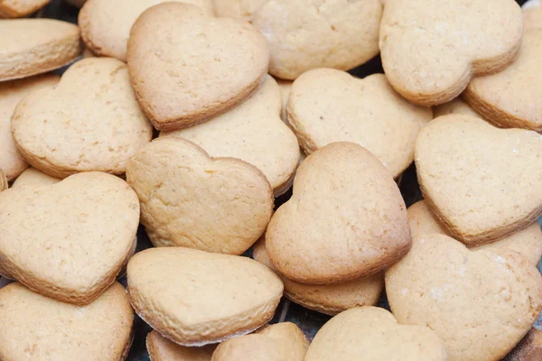 Lots of freshly baked heart shaped biscuits — Stock Photo, Image