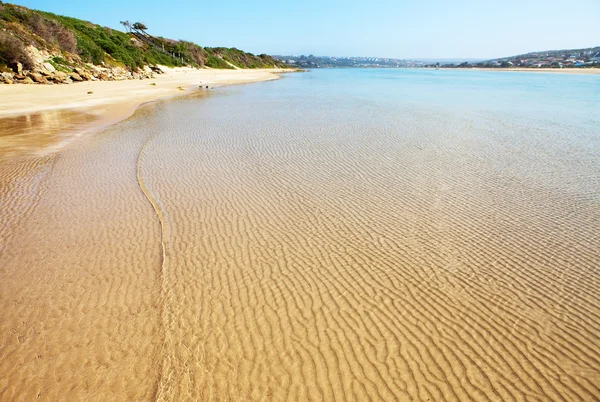 Plage vide avec des ondulations dans le sable et l'eau — Photo