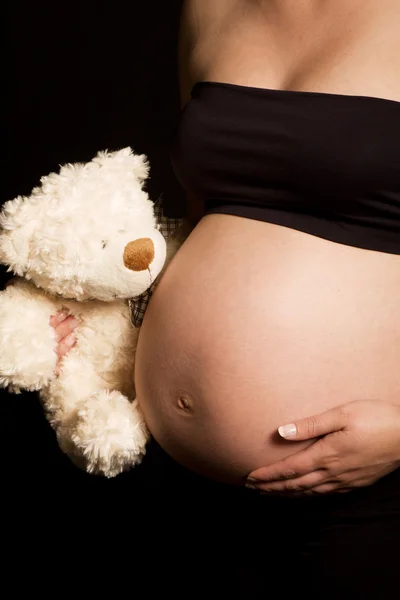 Jeune femme enceinte caucasienne tenant ours en peluche — Photo