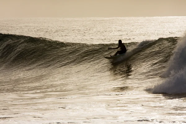 Young male riding a wave on his paddle-ski — Stock Photo, Image