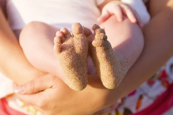 Pés de bebê cobertos de areia de praia — Fotografia de Stock