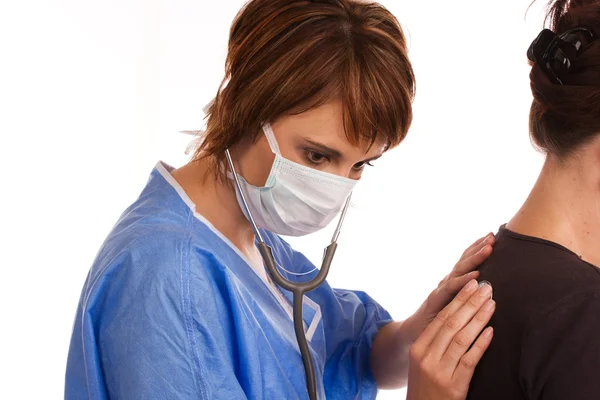 Kvinnliga läkare undersöka en patient med ett stetoskop — 图库照片