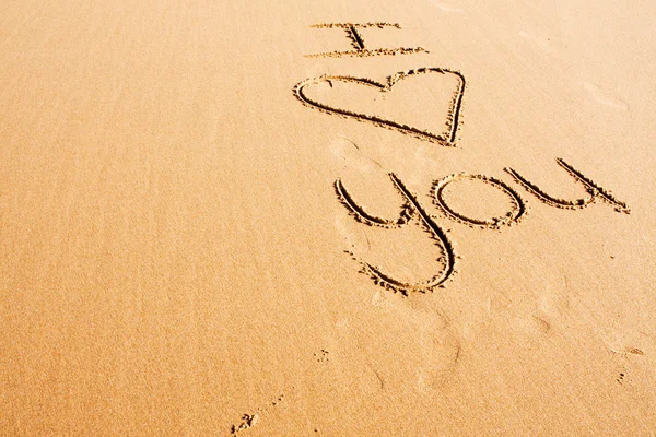 Aanhankelijk woorden geschreven in het strand zand — Stockfoto