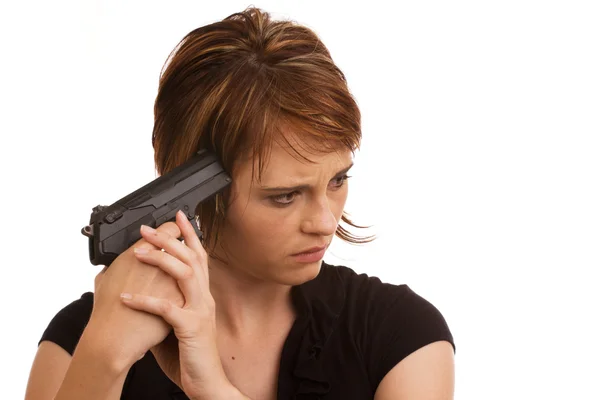 Молодая кавказская девушка держит пистолет у головы — стоковое фото