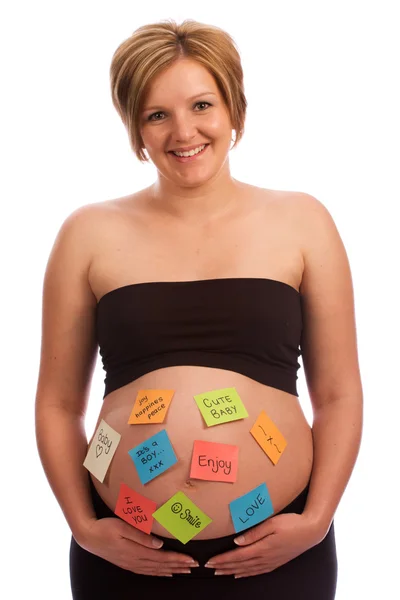 Vackra gravid kvinna med självhäftande anteckningar på mage — Stockfoto
