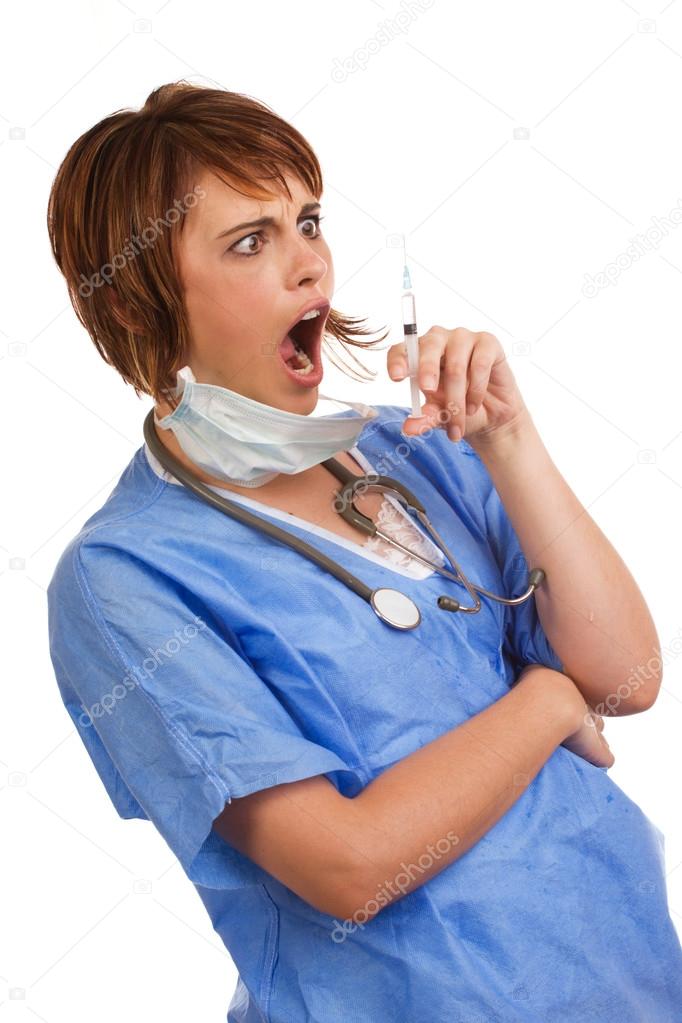 Shocked female doctor holding filled syringe