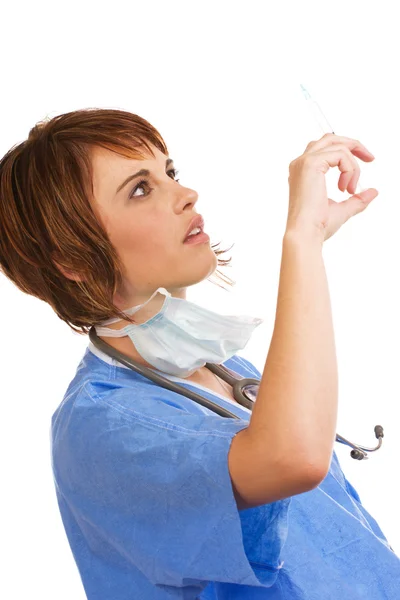 Attractive young Caucasian female doctor checking syringe — Stock Photo, Image