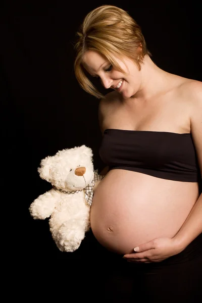 Atractiva mujer embarazada sosteniendo oso de peluche — Foto de Stock