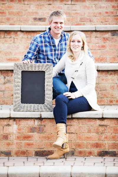 Caucasian couple sitting on brick steps — Stock Photo, Image