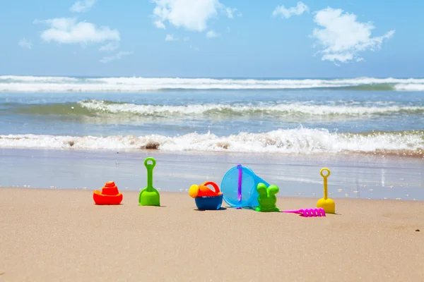 Jouets de plage en plastique sur la plage avec mer en arrière-plan — Photo