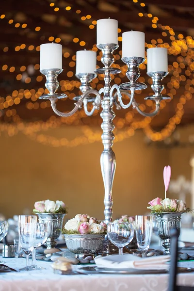 Kandelaar & bloemen op tafel bij de bruiloft receptie — Stockfoto