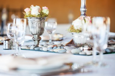 Düğün resepsiyonunda gümüş vazoda gül buketi