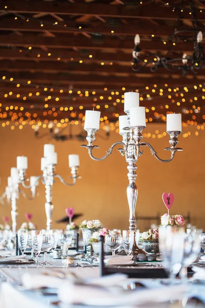 Candelabra with candles on decorated wedding reception tables — Stock Photo, Image