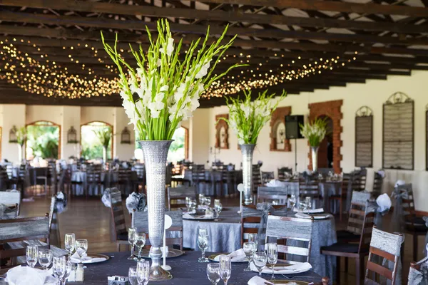 Local de recepção de casamento com mesas decoradas e luzes de fadas Fotografias De Stock Royalty-Free