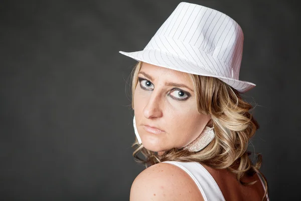 Young blonde woman with serious face wearing white hat — Stock Photo, Image