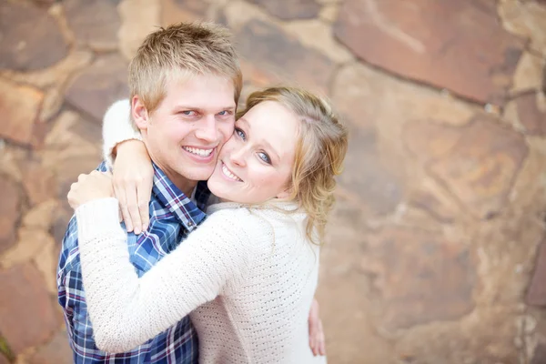 Junges verliebtes erwachsenes Paar lächelt, während es sich umarmt — Stockfoto