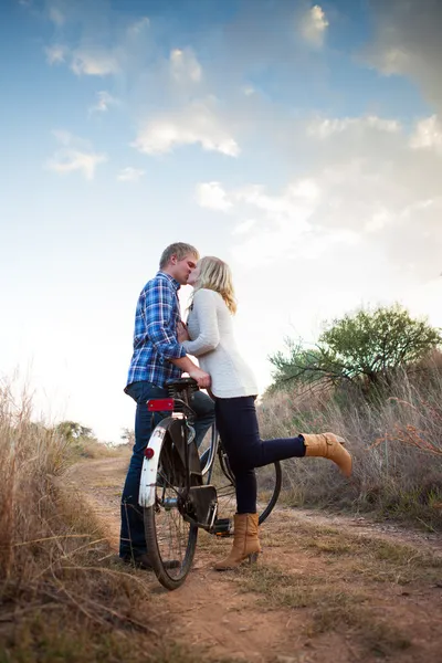 Young adult couple with old bicycle kissing — Stock Photo, Image