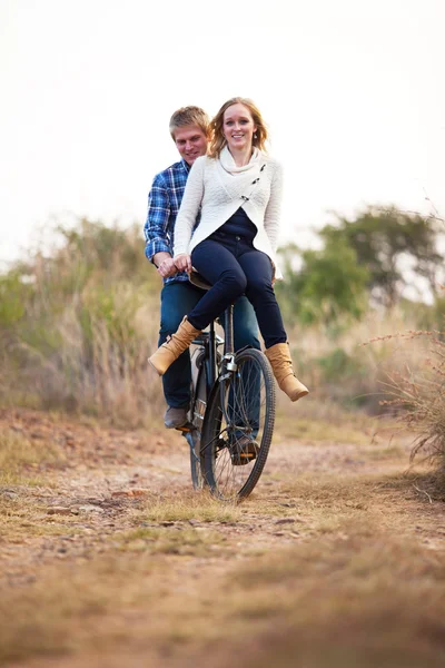 Pareja feliz montando bicicleta vieja en el camino de tierra —  Fotos de Stock