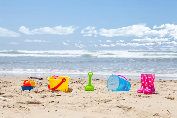 Brinquedos de praia de plástico brilhantemente coloridos na praia — Fotografia de Stock