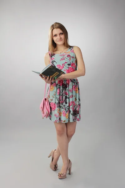 Hermosa chica de color rosa posando con un libro, una dama de negocios . — Foto de Stock