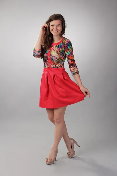 Mooi lachen meisje in een rode jurk — Stockfoto