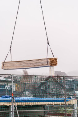 Yeni bir ev inşaatı - vinçle kereste teslimatı yapılan bir inşaat alanı