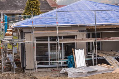 Tek kişilik ev inşaatı - yapı iskelesi ve çatı brandası olan bungalov kabuğu inşaatı