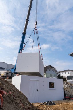 Crane garajın parçalarını kuruyor. İnşaat vinci olan bir inşaat alanı.